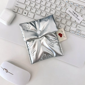 Close-up of silver quilted storage bag with butterfly embossing and secure snap button