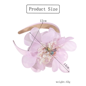 Macro detail of a 12x14cm pink fabric flower headband with crystal bead center decoration
