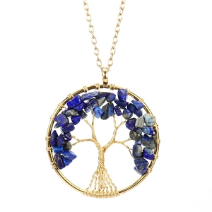 Detailed close-up of handmade gold wire Tree of Life pendant with blue lapis lazuli stones