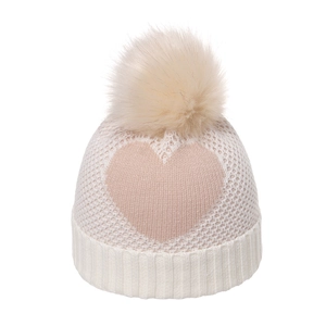 Winter knit hat for girls featuring pink heart patterns and a cream faux fur pompom