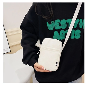 Detail of white corduroy mini crossbody phone bag with SPORT logo tag and zipper