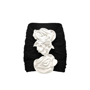 Detail of black mini dress featuring white 3D fabric roses and ruched texture fabric