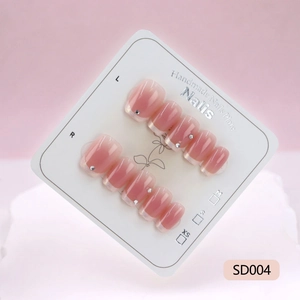 Pink gradient press-on nails with silver studs displayed on professional card