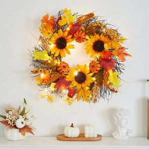 Autumn wreath with sunflowers, pumpkins, and LED lights on a natural branch base