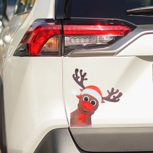 Detailed view of a reflective Christmas reindeer magnetic decal on a white car trunk