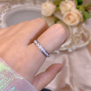Detail view of a silver open ring featuring intertwined bands and sparkling cubic zirconia