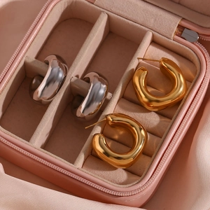 Polished gold and silver U-shaped hoop earrings displayed in a luxury pink jewelry box