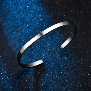 Macro shot of silver polished C-shape stainless steel cuff bracelet on starry bokeh background
