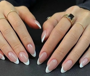 Classic almond-shaped French nails with nude pink base and white tips on hands