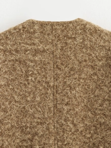Close-up of brown faux shearling texture and stitching detail on the fashion V-neck coat