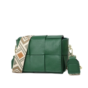 Close-up of green woven leather texture and diamond pattern strap on crossbody bag
