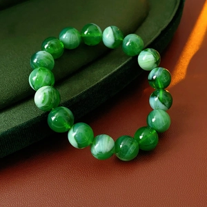 Macro shot of green and white jade-style round beads bracelet with natural patterns