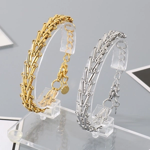 Minimalist V-shaped horseshoe chain bracelets in gold and silver finishes on a stand