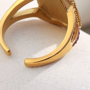 Macro d'une bague plaquée or 18 carats avec pierres violettes et détail d'anneau réglable