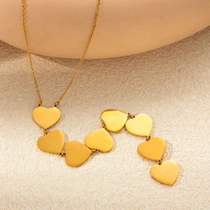 Elegant gold titanium steel necklace featuring multiple heart pendants in a minimalist style