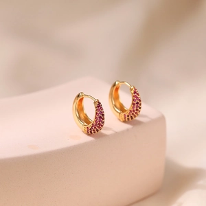 Close-up of gold plated brass hoop earrings set with micro-pave red cubic zirconia