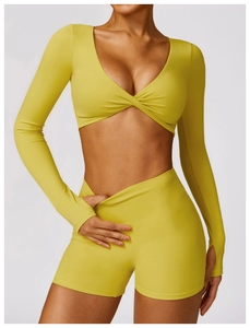 Détail du crop top torsadé à manches longues avec passe-pouces et ensemble short yoga