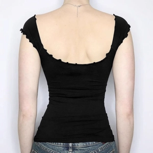 Slim fit backless black knit top with ruffled trim and deep U-neck for summer style