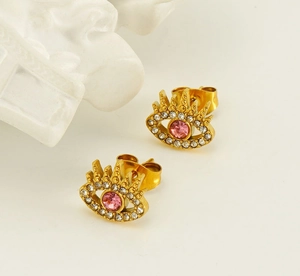 Close-up of gold eye stud earring featuring a pink zircon and micro-pave crystals