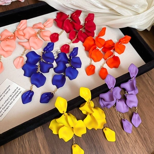 Macro shot of colorful rose petal tassel earrings in pink red blue and yellow styles