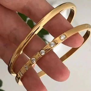 Polished gold plated titanium steel bangle set with sparkling cubic zirconia accents
