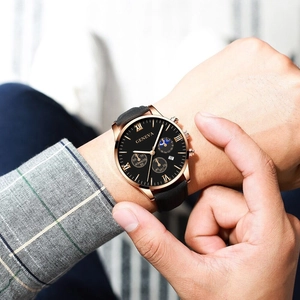 Close-up of Geneva men's watch with golden case and black dial worn on wrist