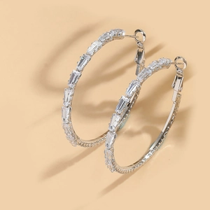 Detail of silver hoop earrings with rectangular and round pavé cubic zirconia