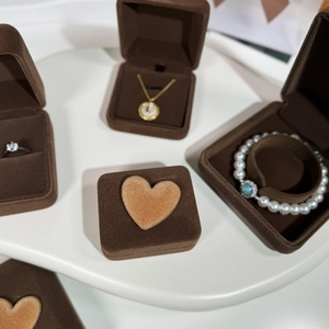 Detail of brown velvet jewelry boxes with heart decor for rings and necklaces