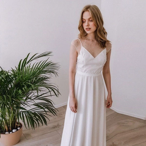 Elegantes weißes Hochzeitskleid mit Perlen am Netzausschnitt und fließendem Rock