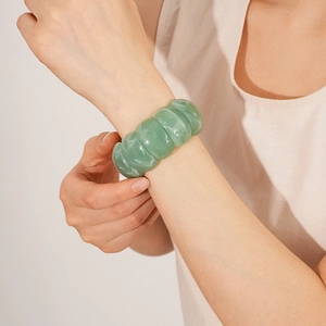 Close-up of green bamboo style acrylic bracelet with marble texture on female wrist