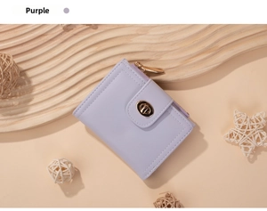 Close-up of a purple minimalist short wallet with a gold twist-lock and zipper detail