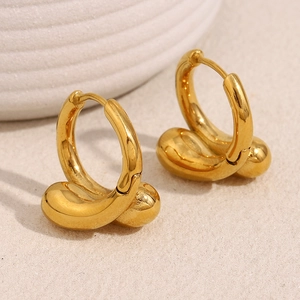 Détail macro de boucles d'oreilles gouttes dorées avec une finition en métal poli