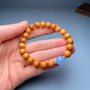 Macro view of sandalwood beads bracelet with blue gemstone and crystal spacers on wrist