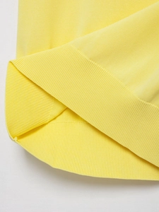 Dettaglio macro del maglione in maglia giallo limone con bordo a costine e cuciture fini