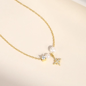Macro detail of gold S925 sterling silver star pendant necklace with pearls and zircon