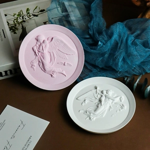 Close-up of vintage angel relief trays in pink and white with classical matte finish