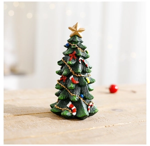 Detailed resin Christmas tree miniature with golden star and festive ornaments on wood