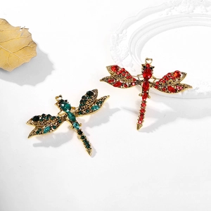 Close-up of vintage dragonfly brooches with emerald and ruby rhinestones in gold alloy