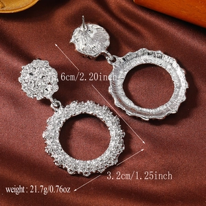 Silver hollow circle earrings with dimensions and weight specs on brown silk