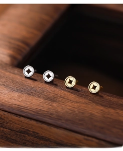 Macro detail of S999 sterling silver money coin stud earrings in gold and silver