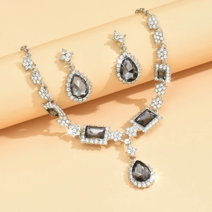 Detail of luxury necklace and earrings set with blue square and teardrop stones