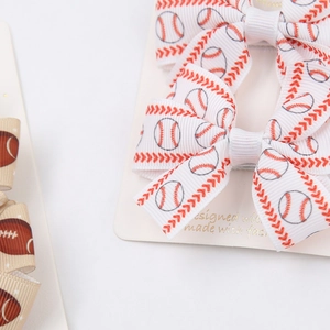 Close-up of baseball and football print grosgrain ribbon bows on a display card