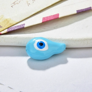 Macro shot of light blue resin evil eye bead for DIY jewelry making and handmade crafts