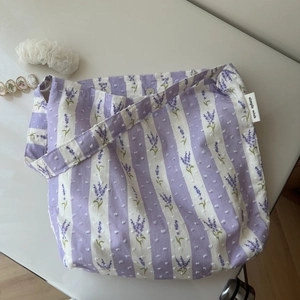 Detail of lavender floral print on purple striped cotton fabric with brand side label