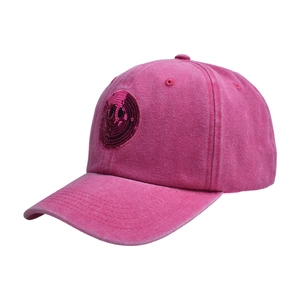 Close-up of sequined smiley face embroidery on a pink washed vintage baseball cap
