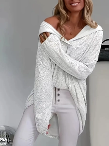 Detailaufnahme der eleganten silbernen Pailletten auf einem lockeren Kapuzenpullover