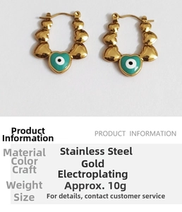 Close-up of gold heart-shaped evil eye earrings with teal inlay and technical details