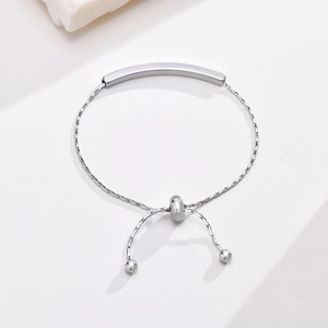 Detail of adjustable silver stainless steel bracelet with curved bar and bead clasp