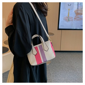 Detail of canvas mini bag with pink and purple striped trim and adjustable strap
