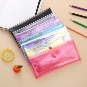 Close-up of colorful glitter PVC pencil cases with snap button closure for stationery